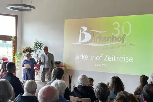 Gäste im Saal mit Präsentation an der Wand